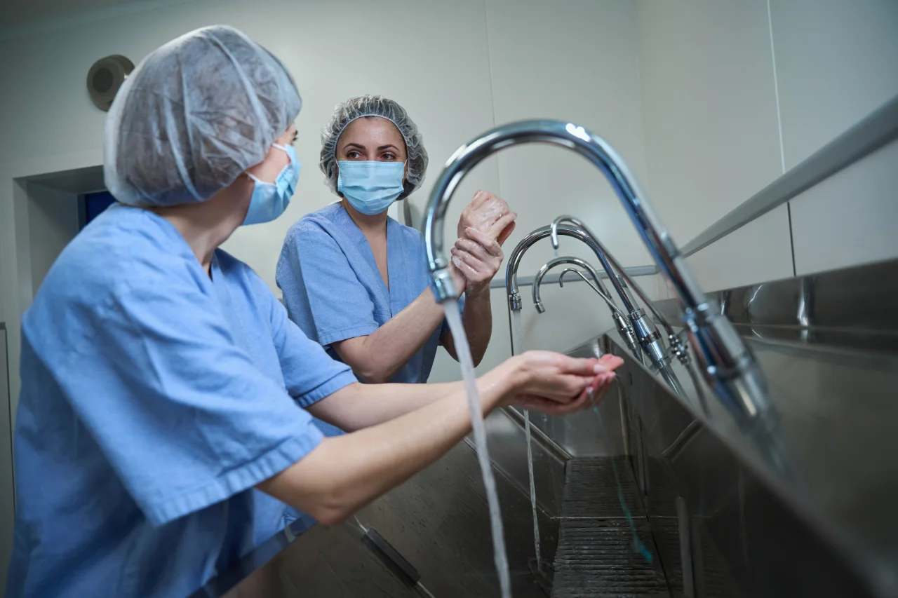 Medical workers washing hands in healthcare building